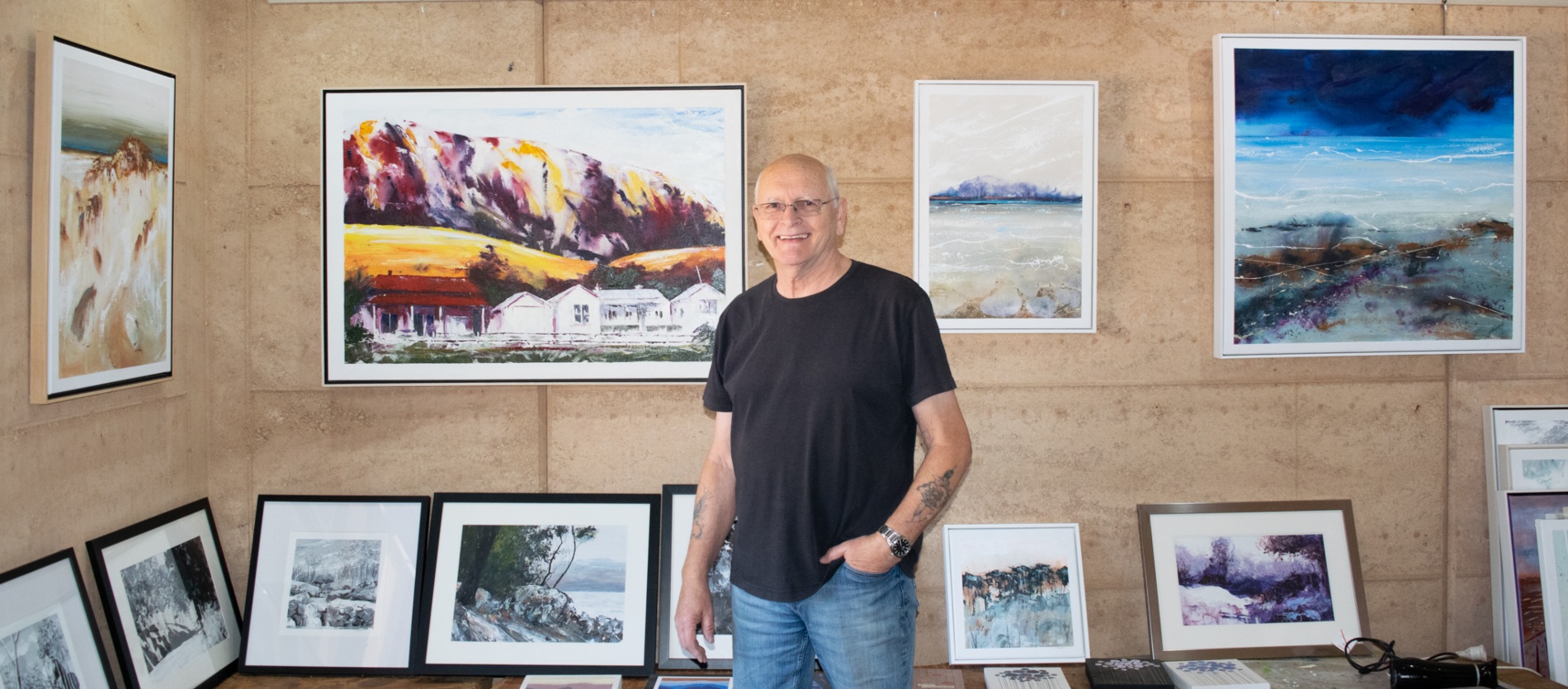 George Hayward in front of a collection of art pieces