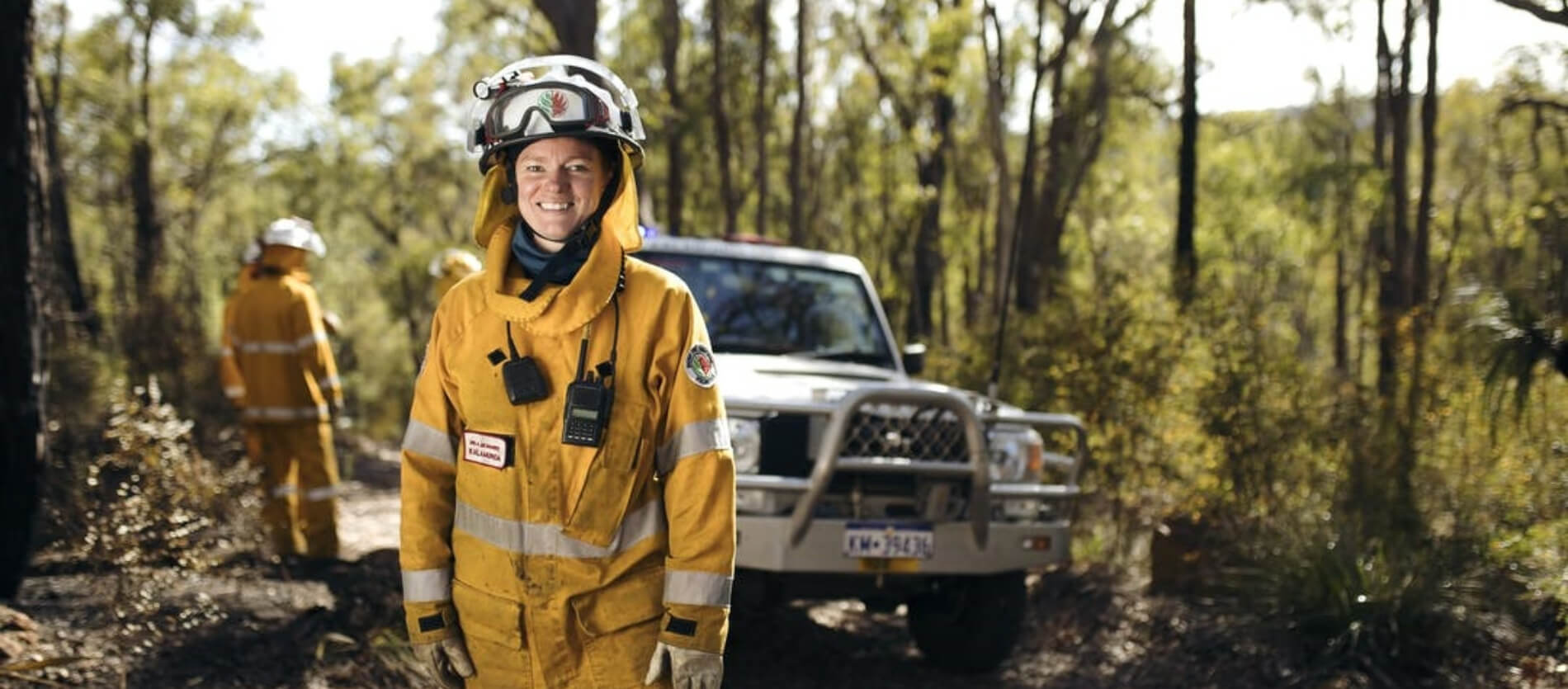 A member of the DFES team in front of their vehicle on a bush track